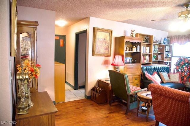 office space with light wood finished floors, a textured ceiling, and a ceiling fan