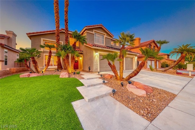 mediterranean / spanish-style home featuring stucco siding, a front lawn, a tile roof, concrete driveway, and a garage