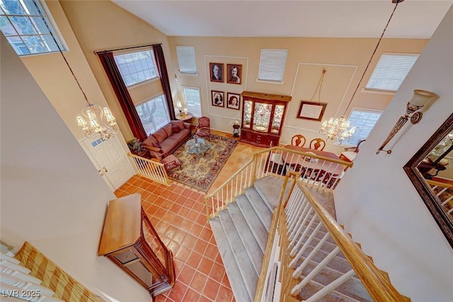 tiled living area with a notable chandelier and a high ceiling