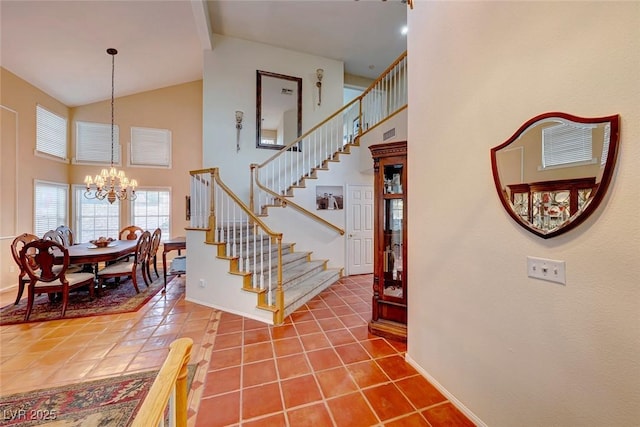 tiled foyer with a chandelier, stairs, and a high ceiling