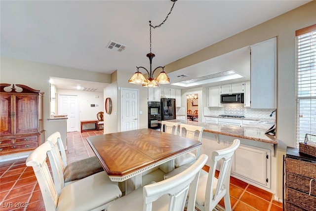 tiled dining room featuring a notable chandelier and visible vents