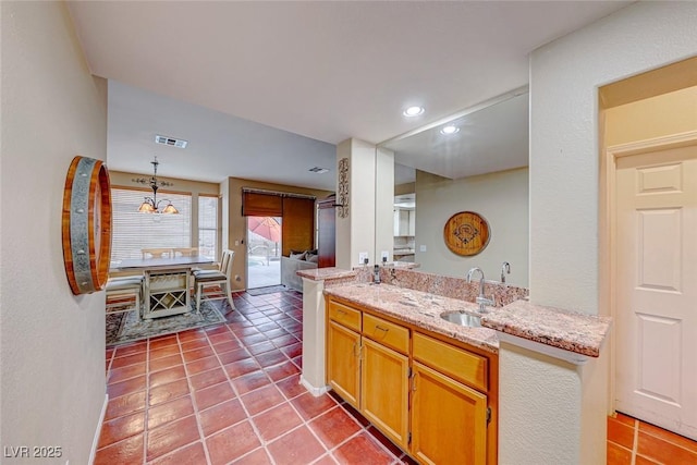 bathroom featuring a sink, visible vents, double vanity, and tile patterned flooring