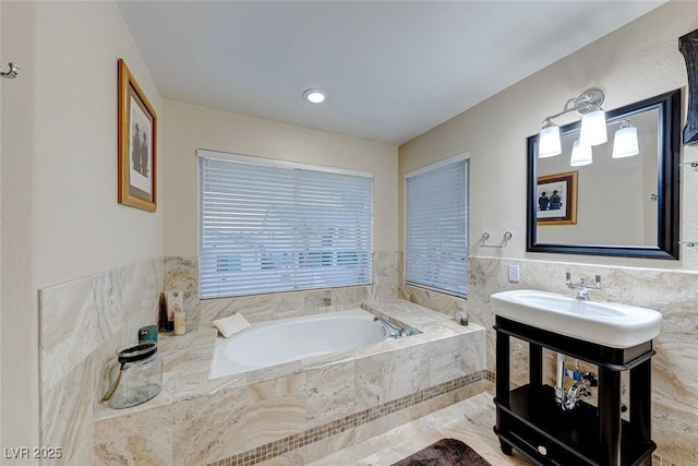 bathroom with a garden tub, tile walls, and vanity