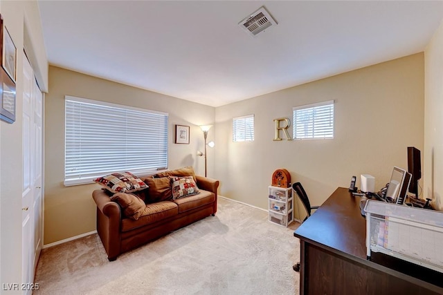 office featuring visible vents, baseboards, and light colored carpet