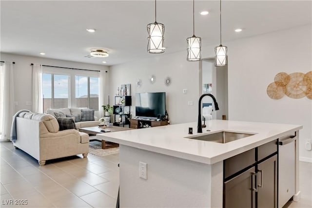 kitchen featuring dishwasher, light countertops, open floor plan, and a sink