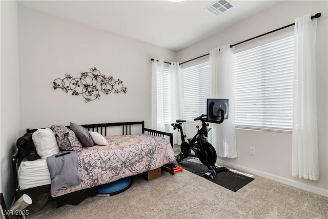 carpeted bedroom featuring visible vents and baseboards