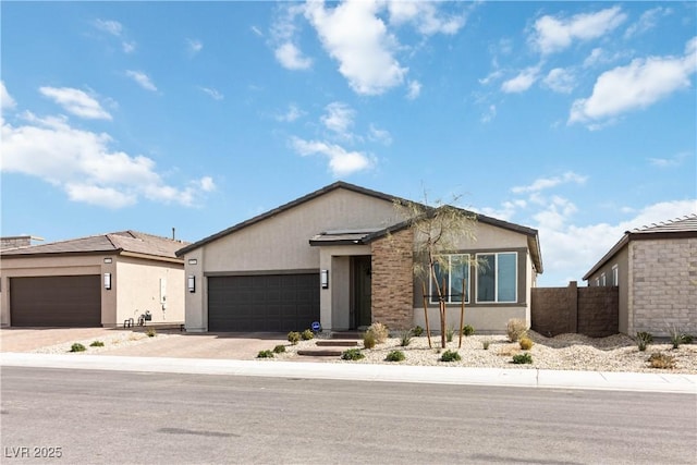 view of front facade featuring concrete driveway, an attached garage, fence, and stucco siding