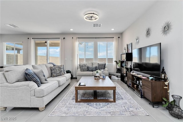 living area with light tile patterned flooring, visible vents, and a wealth of natural light