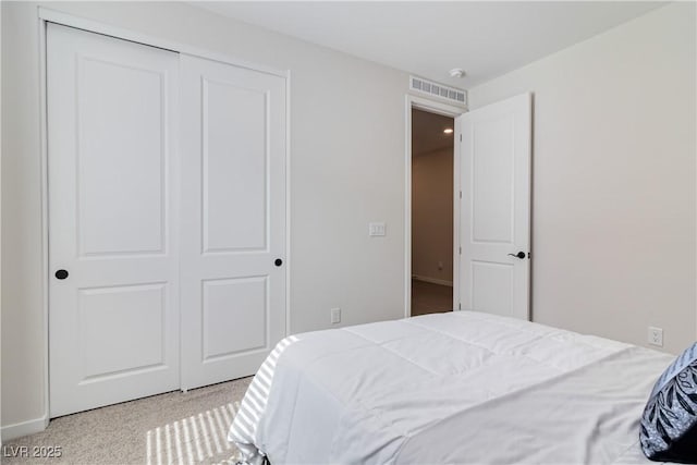 bedroom featuring carpet flooring, visible vents, and a closet