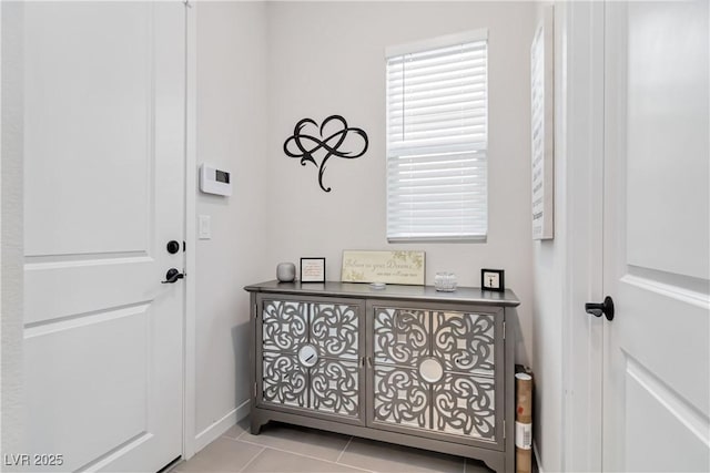 doorway to outside with baseboards and light tile patterned flooring