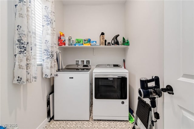 clothes washing area with baseboards, independent washer and dryer, and laundry area