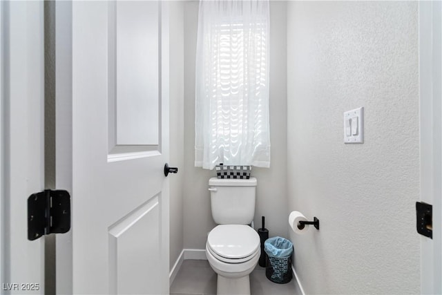 bathroom featuring toilet and baseboards