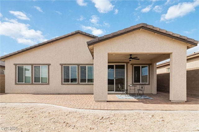 back of property featuring stucco siding, a patio area, a ceiling fan, and fence