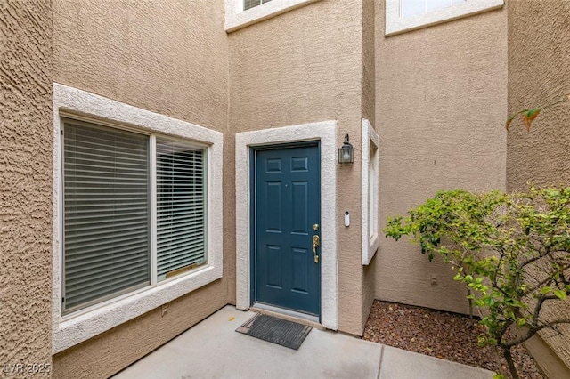 property entrance with stucco siding