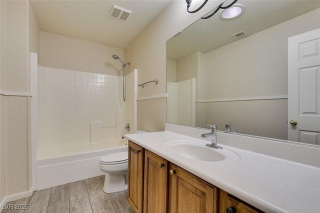 bathroom with washtub / shower combination, visible vents, toilet, and vanity