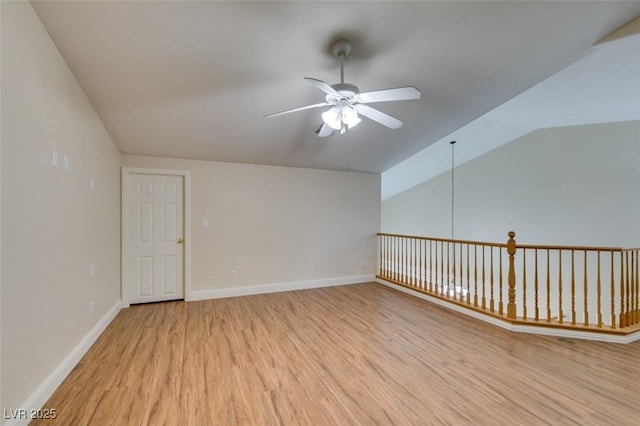 empty room featuring baseboards, light wood finished floors, a ceiling fan, and vaulted ceiling