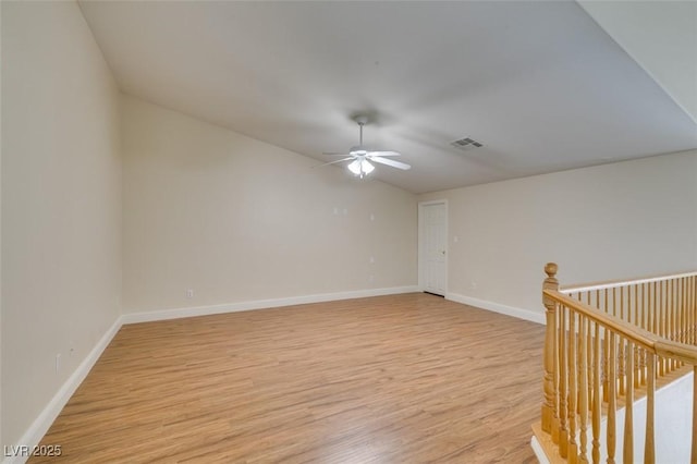 empty room featuring visible vents, baseboards, light wood-type flooring, and ceiling fan