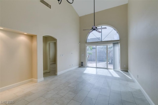 unfurnished room featuring visible vents, baseboards, arched walkways, and ceiling fan