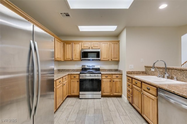 kitchen featuring visible vents, wood tiled floor, recessed lighting, appliances with stainless steel finishes, and a sink