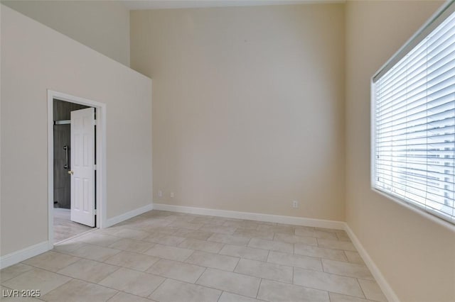 unfurnished room featuring baseboards and light tile patterned flooring