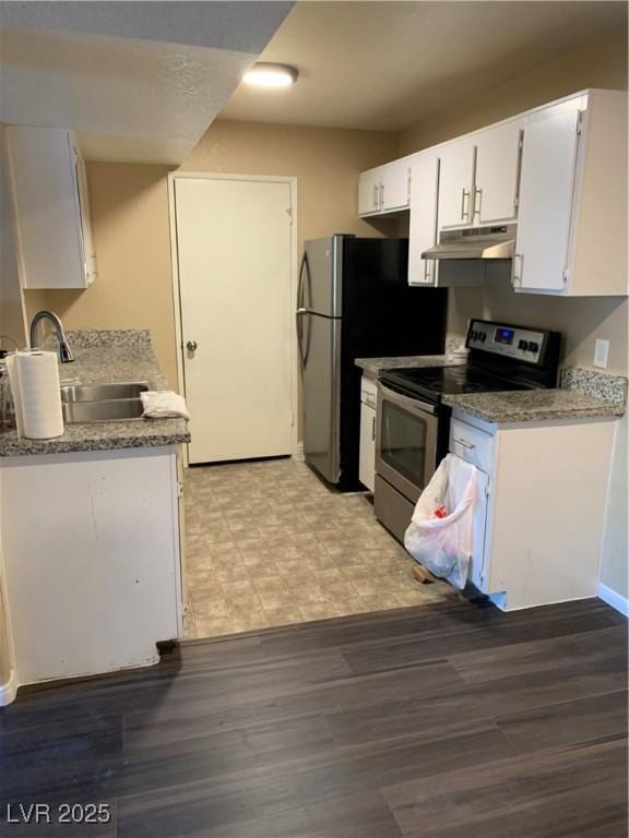 kitchen with under cabinet range hood, light floors, white cabinets, stainless steel appliances, and a sink