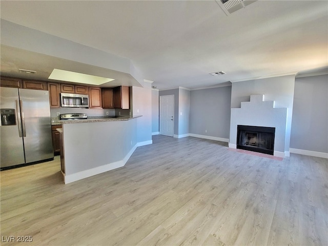 kitchen featuring visible vents, stainless steel appliances, light wood-type flooring, and baseboards