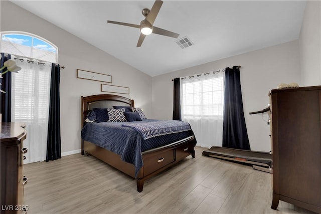 bedroom with baseboards, visible vents, light wood finished floors, ceiling fan, and vaulted ceiling