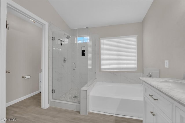 full bathroom with vanity, wood finished floors, baseboards, a stall shower, and a garden tub