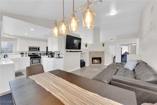 living area featuring recessed lighting, a fireplace, visible vents, and baseboards