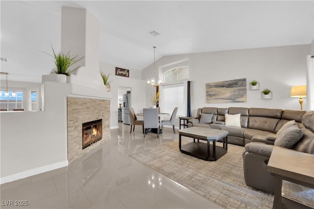 living room featuring visible vents, an inviting chandelier, a fireplace, baseboards, and vaulted ceiling