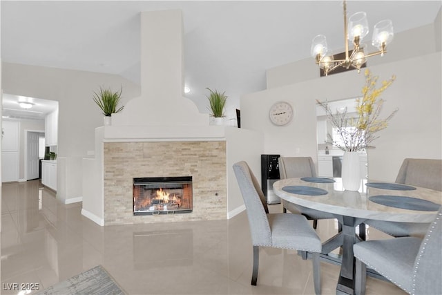 dining space with a tile fireplace and an inviting chandelier