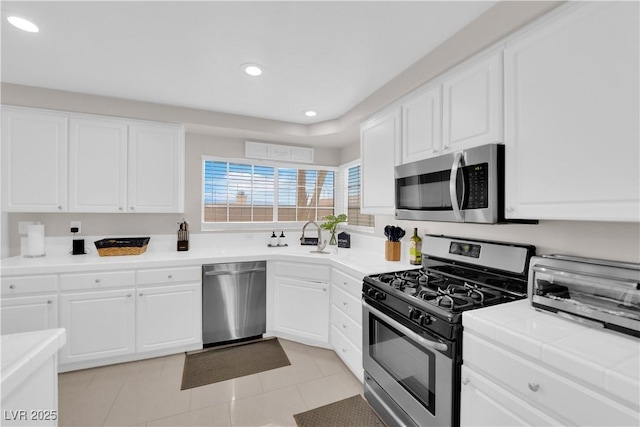 kitchen with recessed lighting, white cabinets, and stainless steel appliances