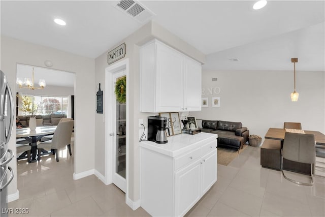 kitchen featuring visible vents, a notable chandelier, open floor plan, white cabinets, and light tile patterned flooring