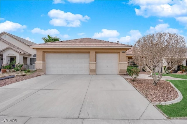 view of front of home featuring concrete driveway, a tiled roof, a garage, and stucco siding