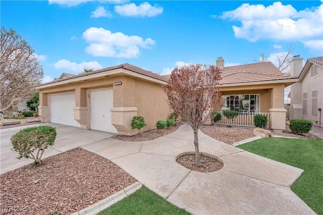 view of front facade with an attached garage, a chimney, stucco siding, concrete driveway, and a tiled roof