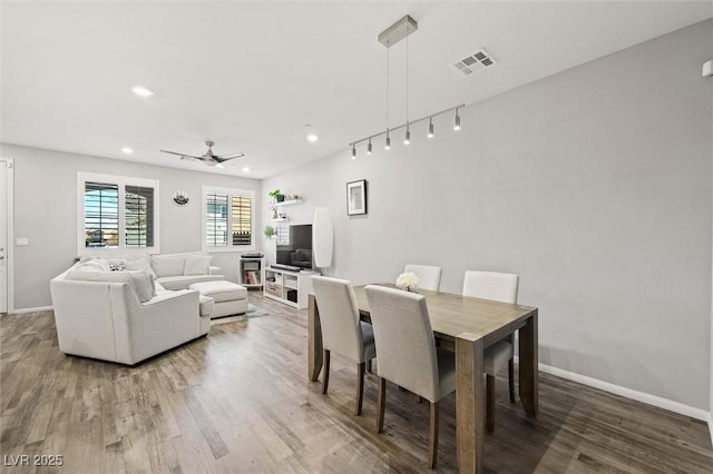 dining area featuring visible vents, ceiling fan, and wood finished floors