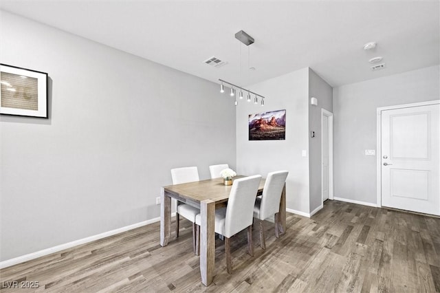 dining space featuring visible vents, baseboards, and wood finished floors