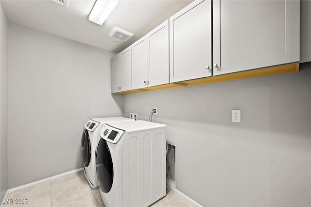 laundry area featuring visible vents, baseboards, light tile patterned floors, cabinet space, and independent washer and dryer