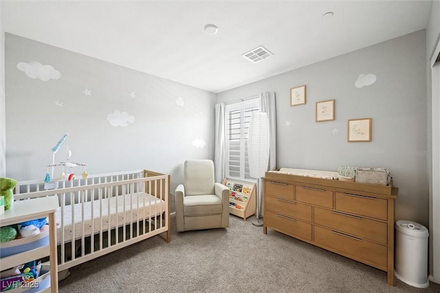 bedroom featuring visible vents, light colored carpet, and a nursery area