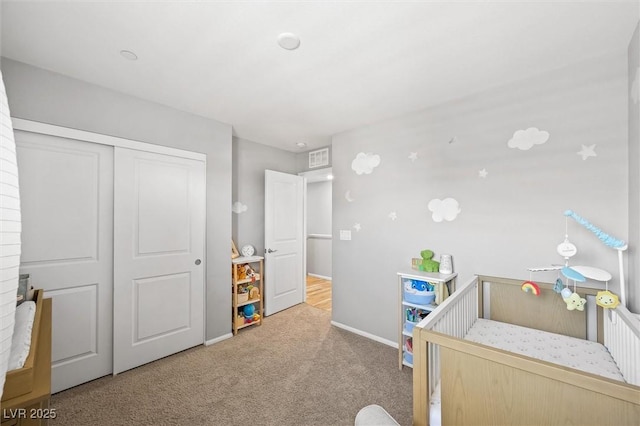 carpeted bedroom featuring a closet and baseboards