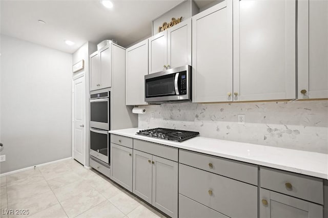 kitchen with recessed lighting, gray cabinetry, light countertops, appliances with stainless steel finishes, and tasteful backsplash