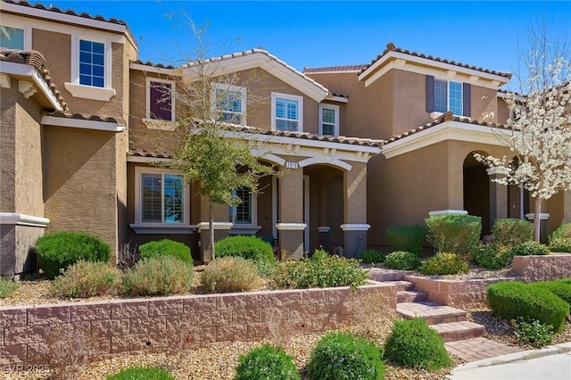 view of front of property featuring stucco siding and a tile roof