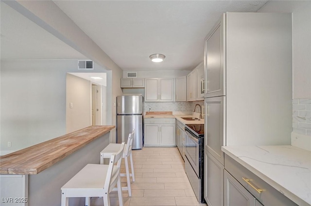 kitchen featuring a sink, visible vents, tasteful backsplash, and appliances with stainless steel finishes