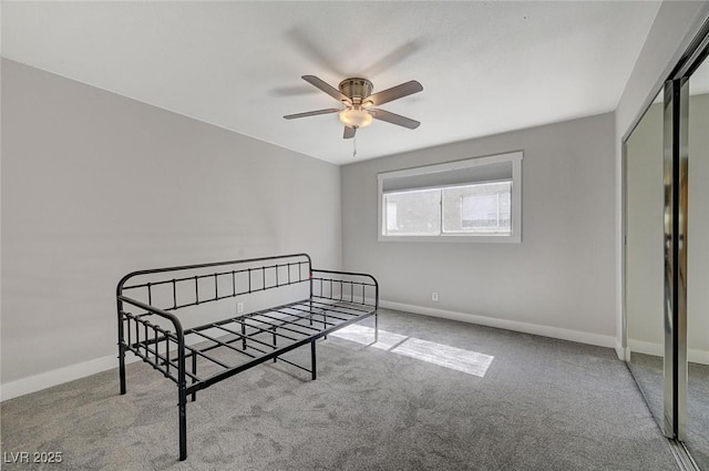 carpeted bedroom with a closet, ceiling fan, and baseboards