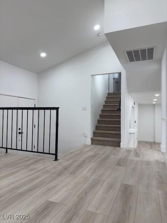 stairway with visible vents, recessed lighting, and wood finished floors