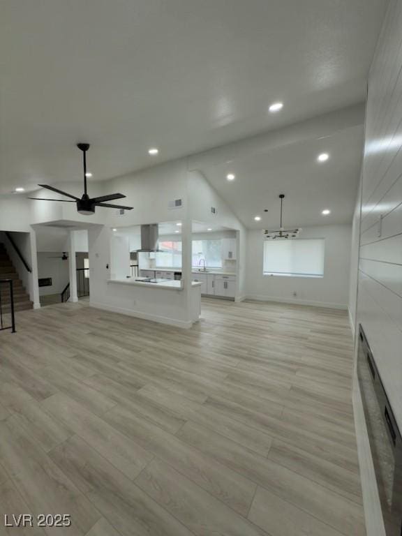 unfurnished living room featuring a sink, recessed lighting, light wood-type flooring, and baseboards