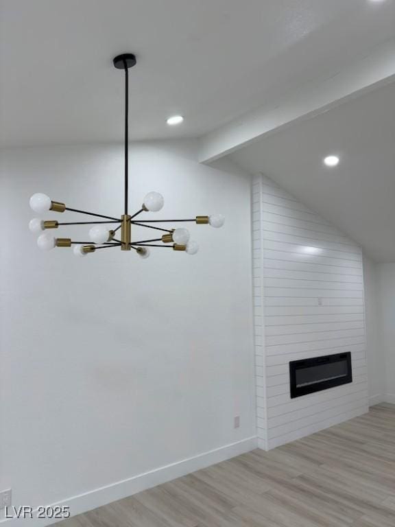 unfurnished living room featuring lofted ceiling with beams, baseboards, wood finished floors, and a fireplace