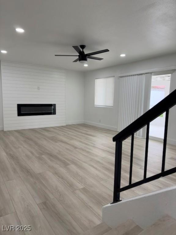 unfurnished living room featuring recessed lighting, light wood-type flooring, a fireplace, and a ceiling fan