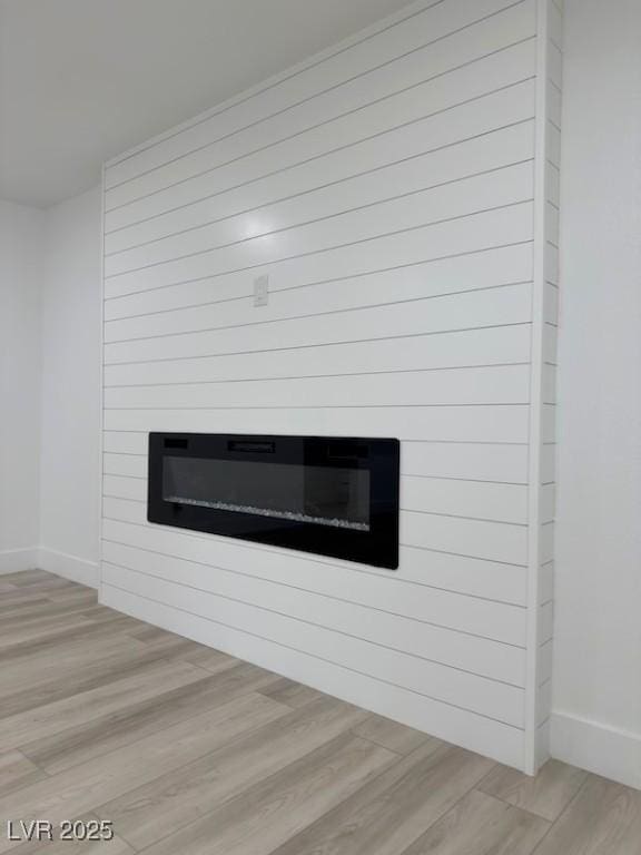 interior details featuring baseboards, wood finished floors, and a fireplace