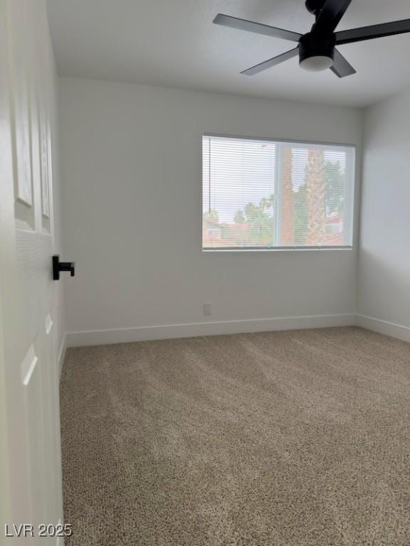 spare room featuring baseboards, light carpet, and a ceiling fan